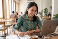Seorang pemula sedang antusias mencatat ide usaha dan merencanakan bisnis dari nol di buku catatannya.